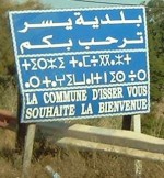 Trojjazyčný nápis v Isseru v Kabylii (Alžírsko) - arabsky, berbersky (uprostřed v tifinaru) a francouzsky. Foto : Wikipedia